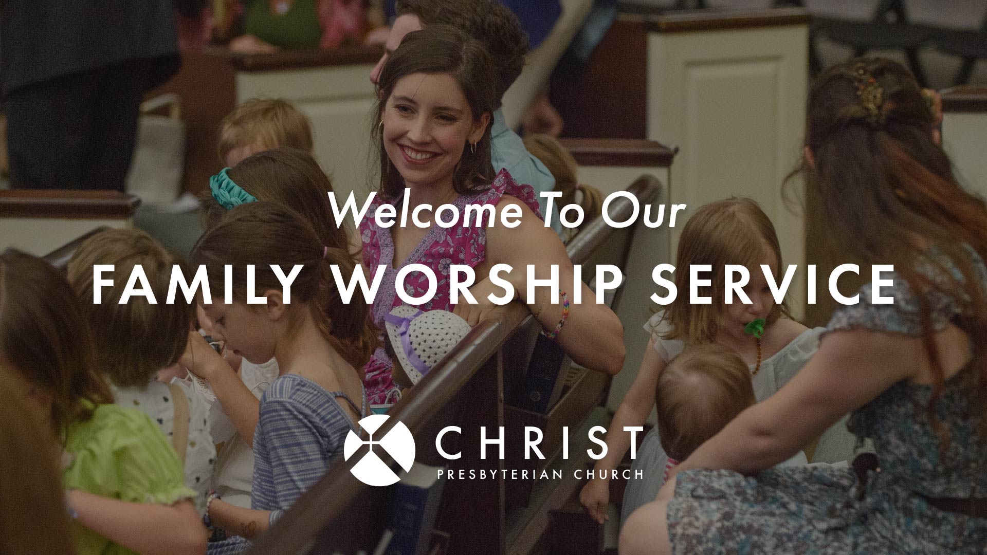 A smiling woman sits among children in a church pew. Text over the image reads, Welcome To Our Family Worship Service. Christ Presbyterian Church.